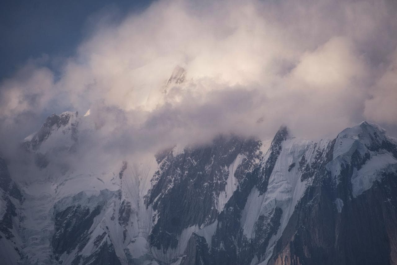 Tourists enjoying campfire dinner in mountains